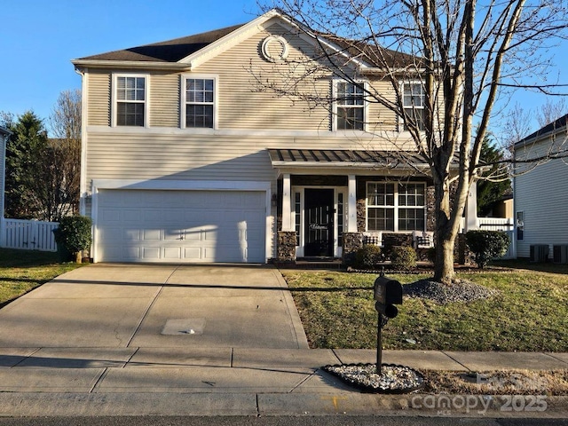 traditional home featuring concrete driveway, covered porch, an attached garage, central AC unit, and fence