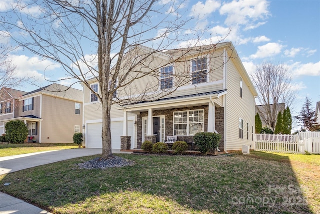 traditional-style house featuring a garage, fence, driveway, stone siding, and a front yard