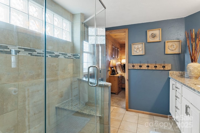 full bath with tile patterned floors, a stall shower, and vanity