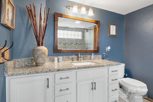 bathroom with vanity, toilet, and a tile shower