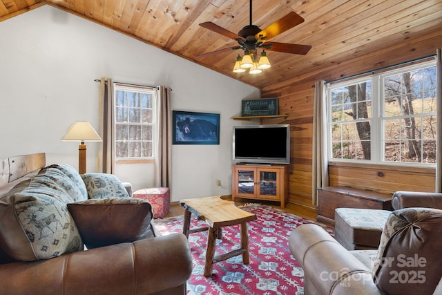 living area with a ceiling fan, lofted ceiling, plenty of natural light, and wood ceiling