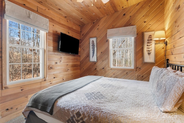 bedroom featuring multiple windows, wood walls, and wooden ceiling