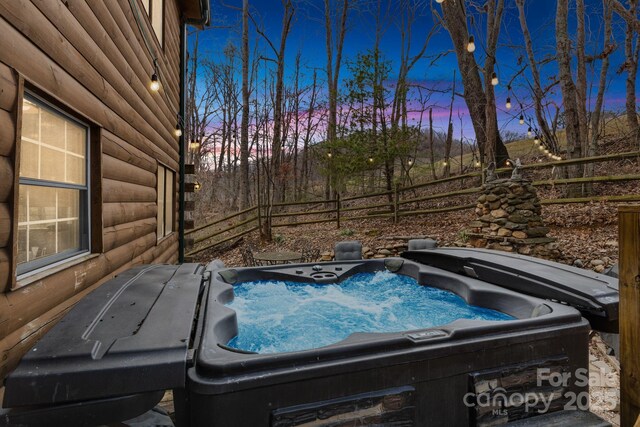 exterior space featuring fence and a hot tub