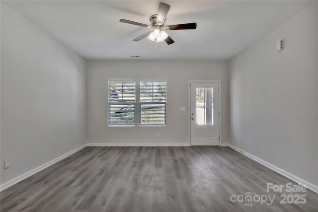 interior space featuring ceiling fan, wood finished floors, visible vents, and baseboards