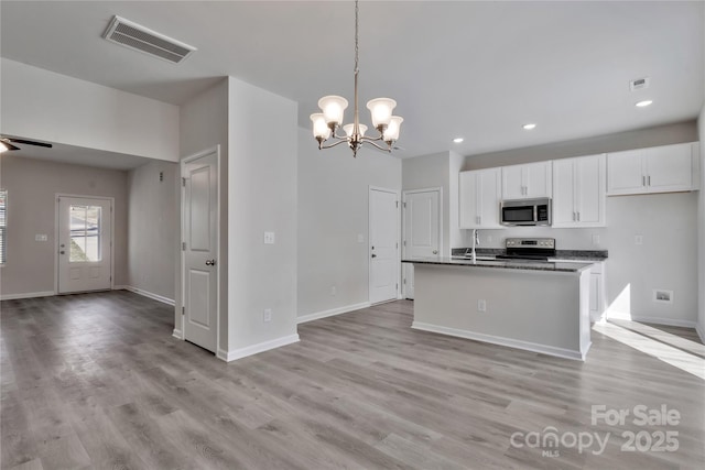 kitchen with open floor plan, appliances with stainless steel finishes, and visible vents