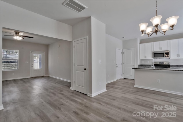 kitchen featuring visible vents, light wood-style flooring, appliances with stainless steel finishes, open floor plan, and white cabinetry