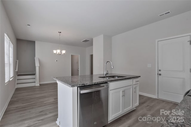 kitchen with visible vents, dishwasher, dark stone countertops, light wood-style floors, and a sink