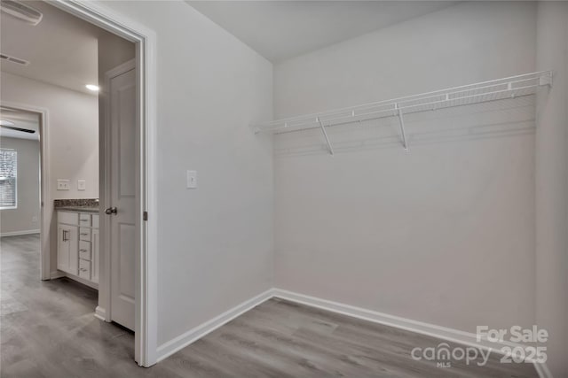 spacious closet featuring visible vents and wood finished floors