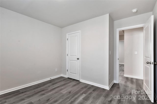 unfurnished bedroom featuring dark wood-style flooring and baseboards