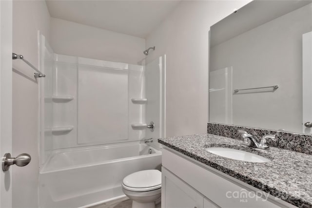 bathroom with tub / shower combination, vanity, and toilet