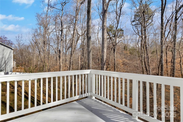 wooden terrace featuring a forest view