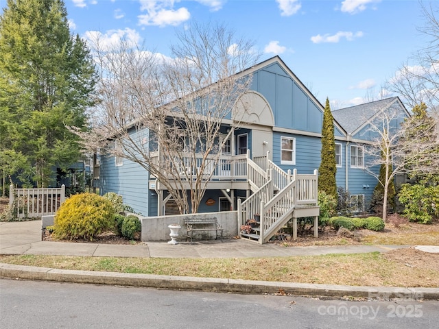 view of front facade featuring stairs and board and batten siding