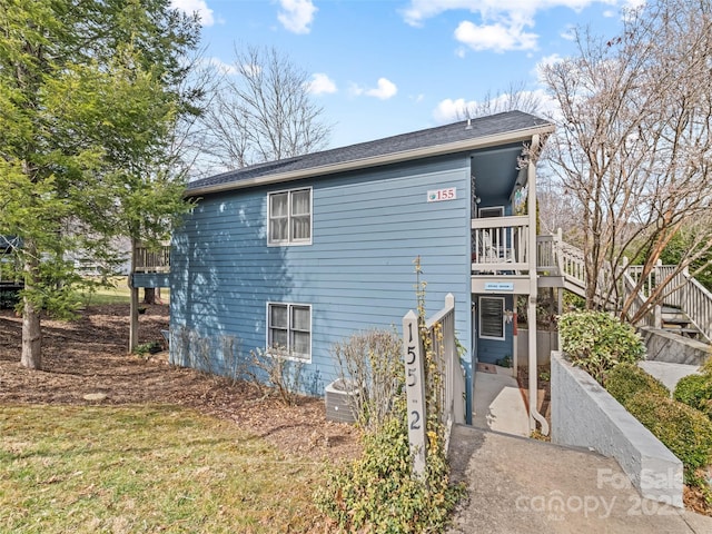 view of side of home featuring stairs and central AC unit