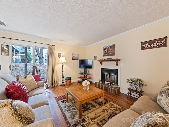 living room featuring a glass covered fireplace, wood finished floors, and crown molding