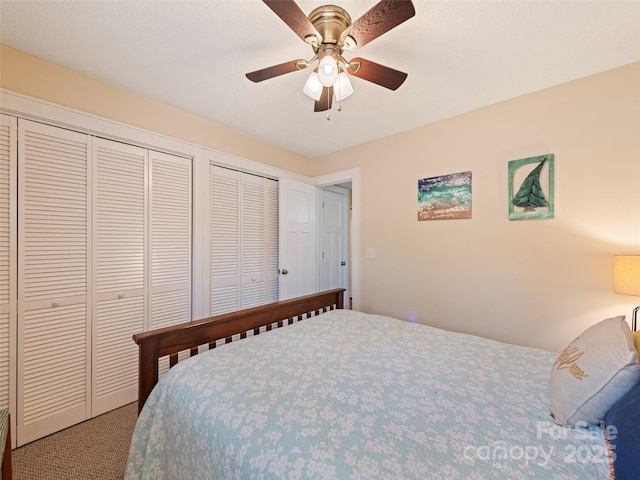 carpeted bedroom featuring a ceiling fan and multiple closets