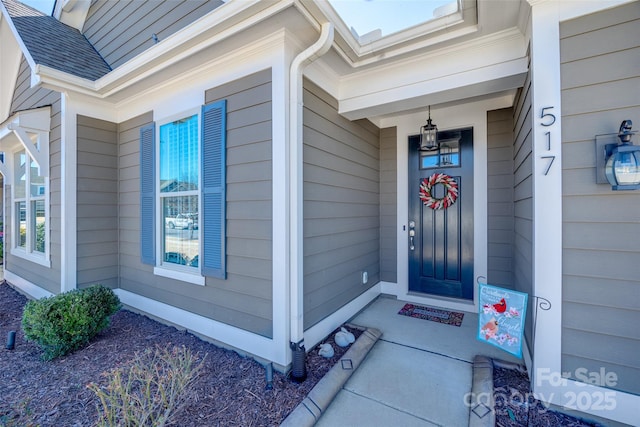 doorway to property featuring roof with shingles