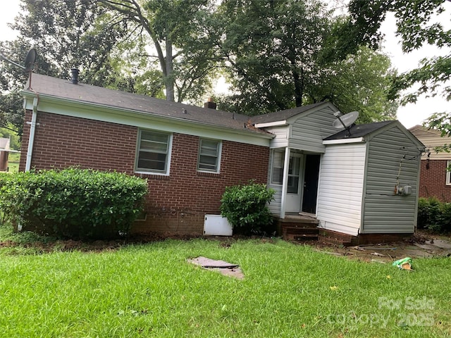 rear view of property featuring crawl space, a yard, and brick siding