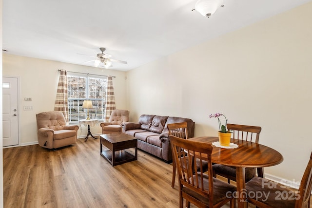 living room with light wood finished floors, ceiling fan, and baseboards