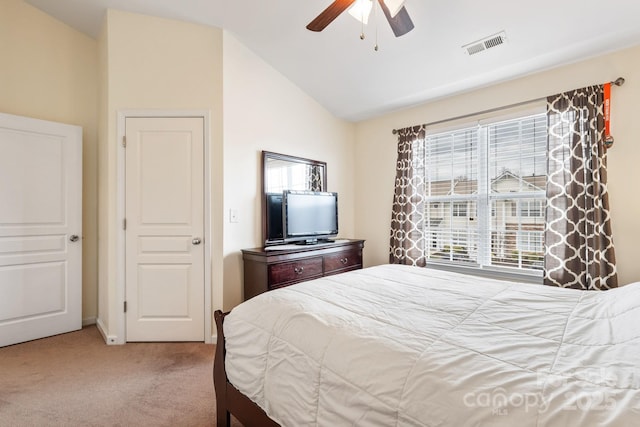 bedroom with carpet floors, visible vents, vaulted ceiling, and a ceiling fan