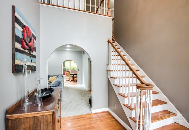 4825 1st Street Ct NW, Hickory, NC 28601 - staircase with arched walkways, wood finished floors, a high ceiling, and baseboards