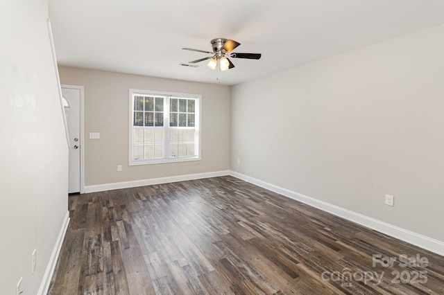 empty room with a ceiling fan, dark wood-style flooring, visible vents, and baseboards