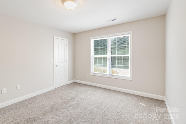 carpeted spare room with baseboards and visible vents