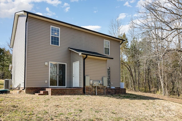 back of property with central AC and a yard