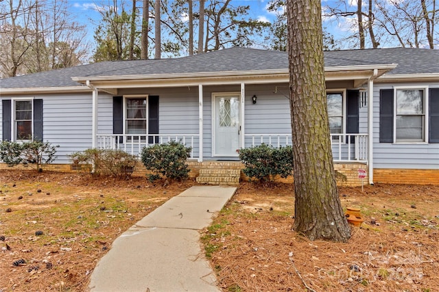 ranch-style home with crawl space, covered porch, and a shingled roof