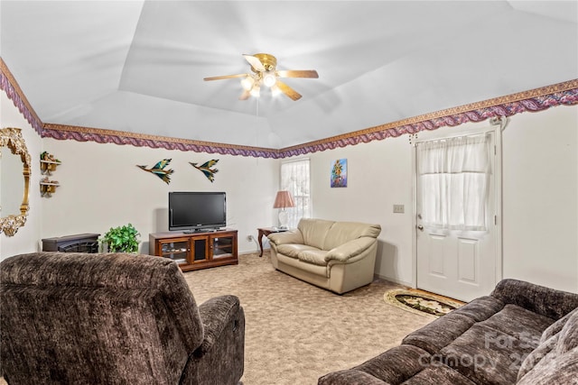 living area featuring light carpet, a raised ceiling, lofted ceiling, and ceiling fan