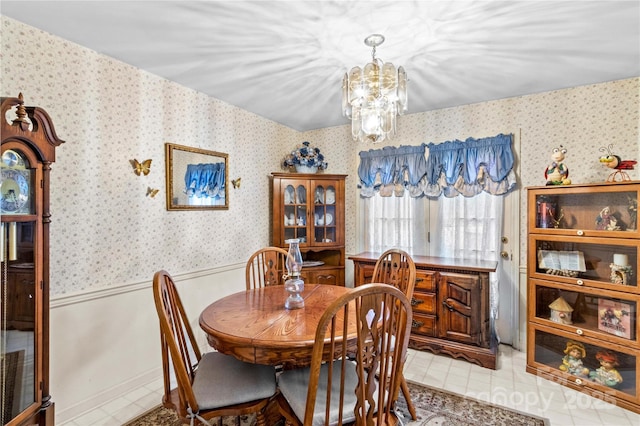 dining room featuring wallpapered walls and wainscoting