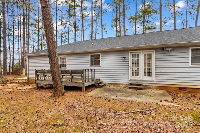 rear view of property with a deck, entry steps, a shingled roof, crawl space, and a patio area