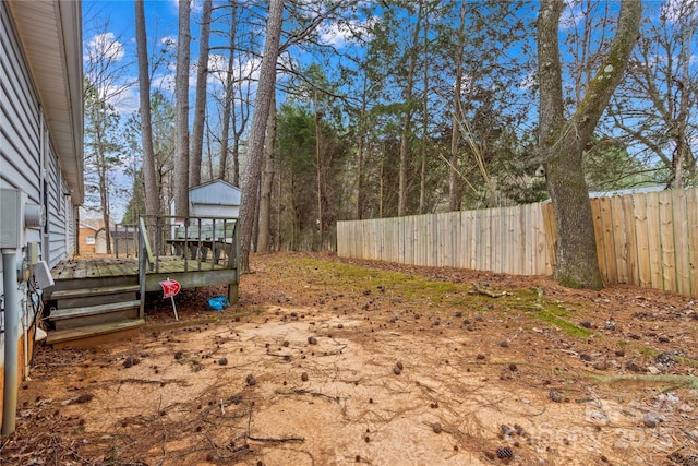 view of yard featuring a wooden deck and fence