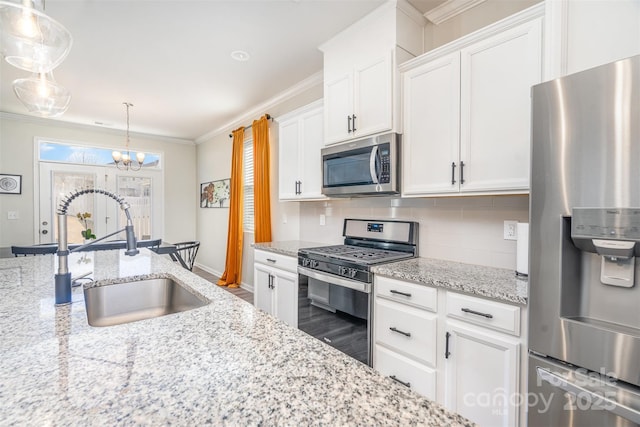 kitchen featuring ornamental molding, a sink, appliances with stainless steel finishes, white cabinetry, and backsplash