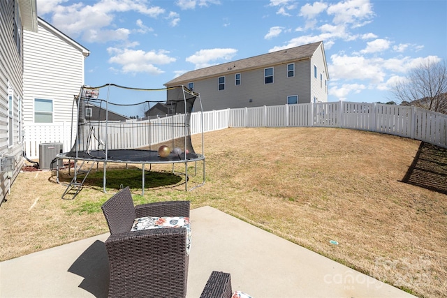 view of yard with cooling unit, a trampoline, a fenced backyard, and a patio area