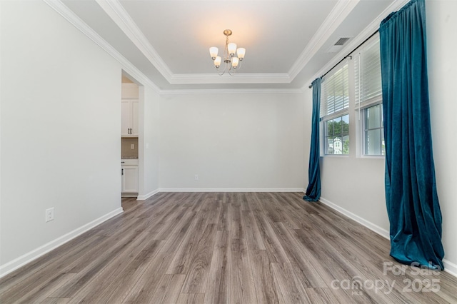 19113 Hawk Haven Ln, Charlotte, NC 28278 - spare room with a chandelier, light wood finished floors, crown molding, and a tray ceiling