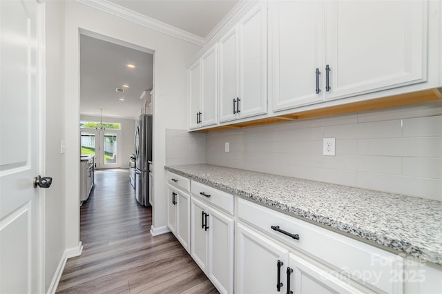 19113 Hawk Haven Ln, Charlotte, NC 28278 - kitchen with freestanding refrigerator, light wood finished floors, white cabinets, light stone counters, and backsplash