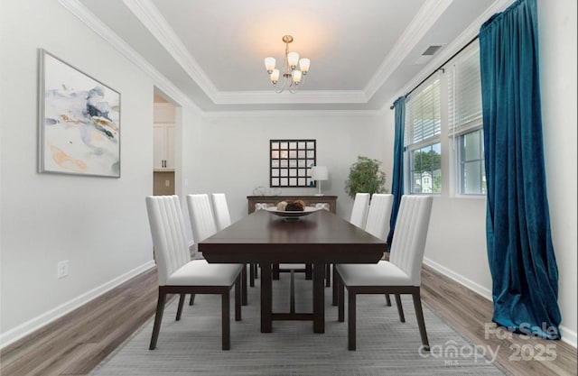 19113 Hawk Haven Ln, Charlotte, NC 28278 - dining room with wood finished floors, a chandelier, ornamental molding, and a raised ceiling
