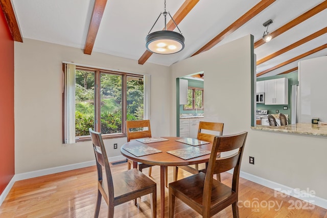 dining space featuring vaulted ceiling with beams, light wood finished floors, visible vents, and baseboards