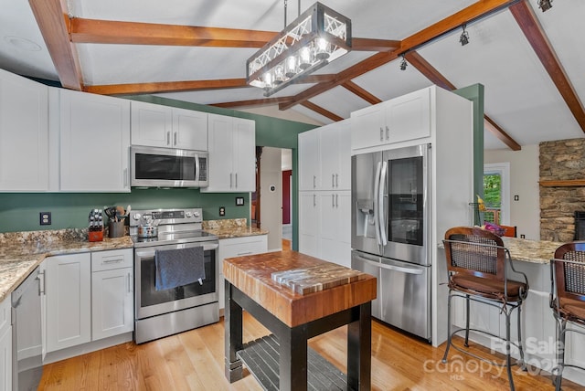 kitchen featuring appliances with stainless steel finishes, light wood-type flooring, and white cabinetry