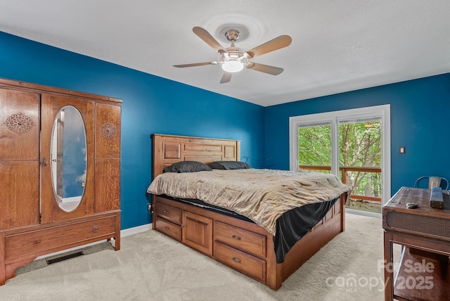 bedroom with light carpet, ceiling fan, visible vents, and baseboards