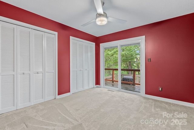 unfurnished bedroom with carpet, access to outside, visible vents, and baseboards