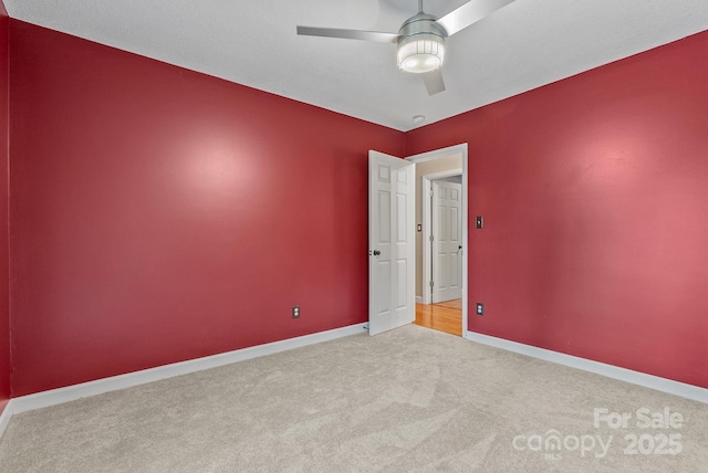 unfurnished room with carpet, a ceiling fan, and baseboards