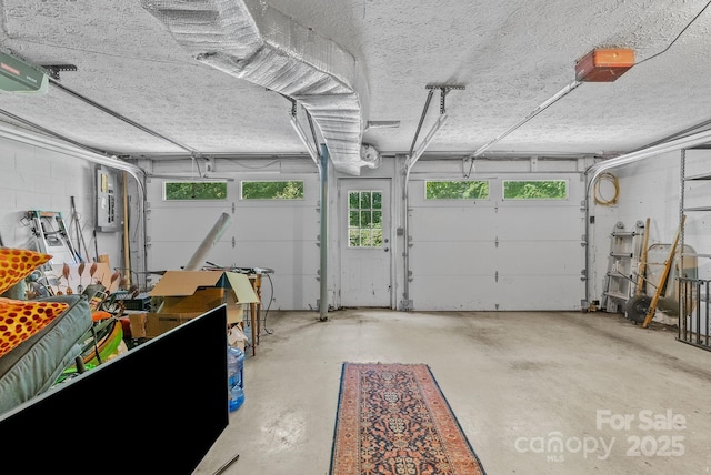 garage with a garage door opener and concrete block wall