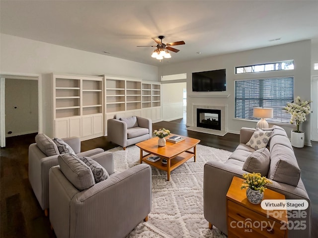 living room with ceiling fan, a fireplace, and wood finished floors