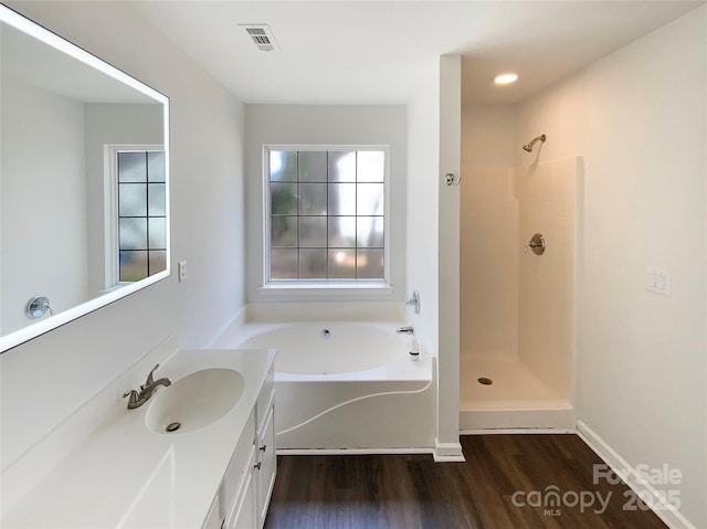 full bathroom featuring a garden tub, wood finished floors, visible vents, vanity, and walk in shower