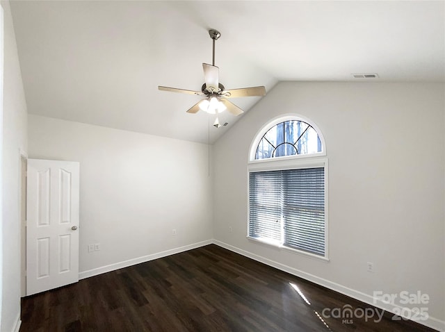 unfurnished room with baseboards, visible vents, lofted ceiling, ceiling fan, and dark wood-style flooring