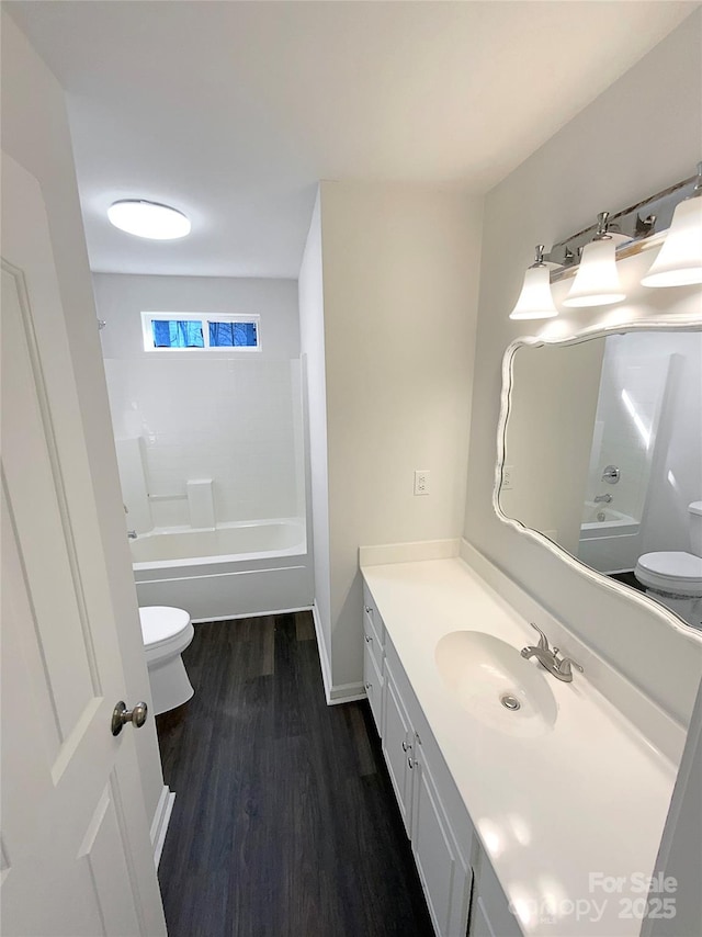 bathroom with bathtub / shower combination, vanity, toilet, and wood finished floors