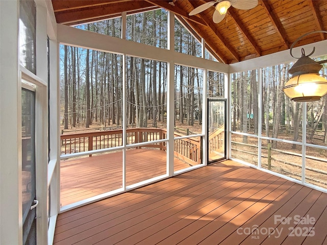 unfurnished sunroom featuring vaulted ceiling with beams, ceiling fan, and wooden ceiling