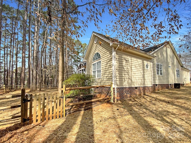 view of side of property featuring crawl space, cooling unit, and fence