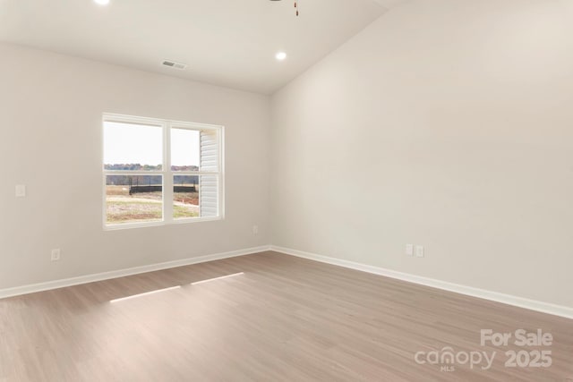 spare room with recessed lighting, wood finished floors, visible vents, baseboards, and vaulted ceiling